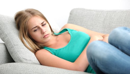 Foto von junger Frau mit Unterleibsschmerzen