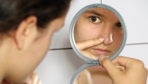 Foto von junger Frau beim Blick in den Spiegel