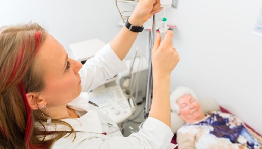 Foto von einer Ärztin, die eine Infusion vorbereitet