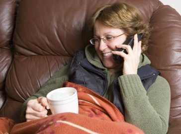 Foto von Frau auf dem Sofa beim Telefonieren