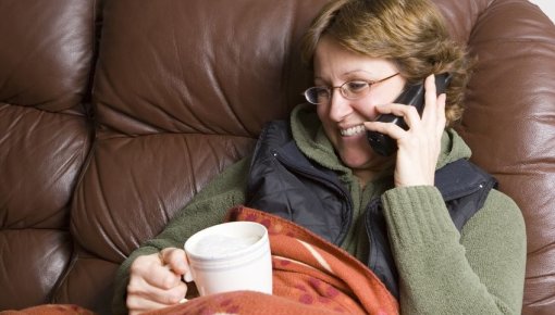 Foto von Frau auf dem Sofa beim Telefonieren