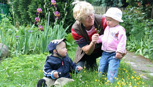 Foto von Großmutter mit Enkelkindern im Garten