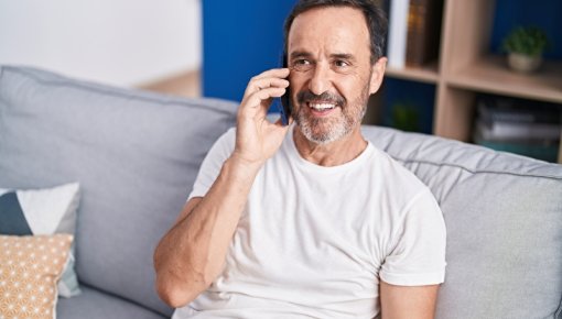 Foto von telefonierendem Mann auf Sofa