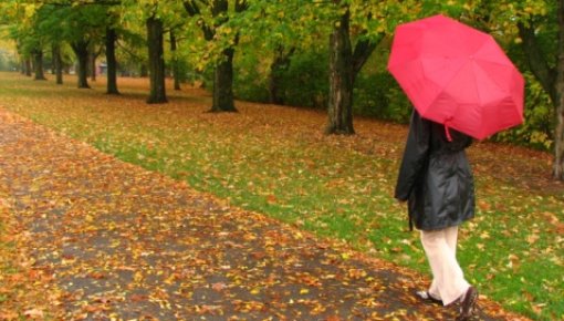 Foto von Frau mit Schirm beim Spaziergang