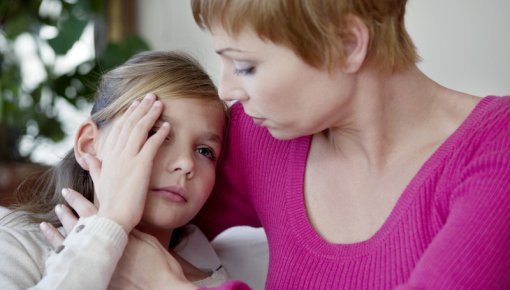 Foto von einer Mutter, die ihre kleine Tochter im Arm hält