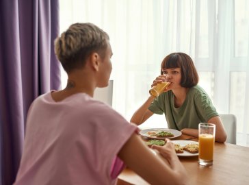 Foto von zwei Freundinnen beim Essen an einem Tisch