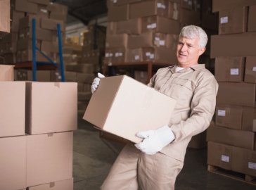 Foto von Lagerarbeiter mit schwerem Paket