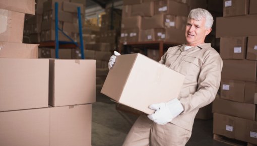 Foto von Lagerarbeiter mit schwerem Paket