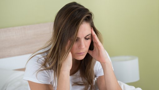 Foto von junger Frau mit Kopfschmerzen