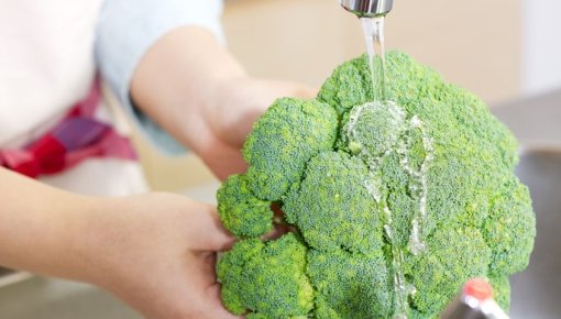 Foto von Frau beim Waschen eines Broccolis