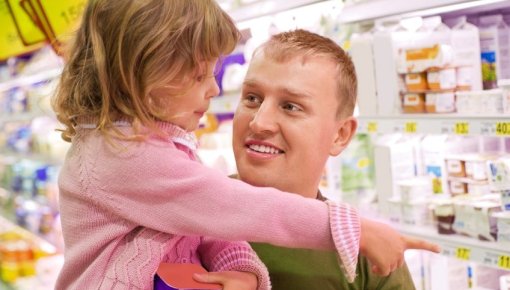 Foto von Vater und Tochter am Kühlregal im Supermarkt