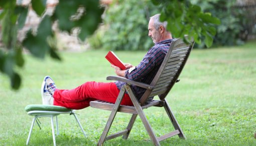 Foto von lesendem Mann im Garten