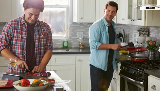 Foto von zwei Männern beim Schneiden von Gemüse in der Küche