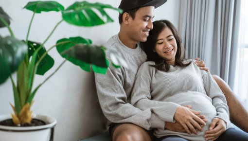 Foto einer Schwangeren und ihres Partners, der sie umarmt