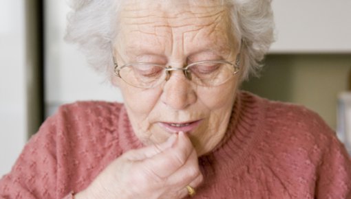 Foto von älterer Frau bei der Tabletteneinnahme