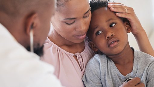 Foto eines fiebernden Kindes, das ärztlich untersucht wird